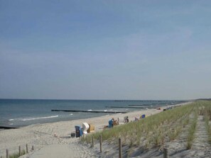 A beach with a sandy shore, a wooden jetty, and a grassy dune. - Haus Bernstein 5 - Apartment - Apartment Bernstein 5 (Graal-Müritz)