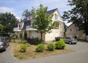 A residential building with a balcony, a driveway, and a lawn with bushes. - Haus Bernstein 5 - Apartment - Apartment Bernstein 5 (Graal-Müritz)