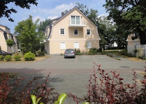Ein zweistöckiges Haus mit einer Auffahrt, auf der ein Auto geparkt ist.