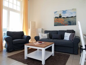 A living room with two dark sofas, a wooden coffee table, and a painting on the wall. - beach street 14-09 . - 14-09 (Kühlungsborn)