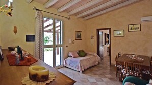 Una habitación acogedora con una cama, una mesa de comedor y un ventanal grande.
