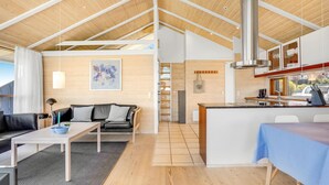 A spacious living area with a high ceiling, a dining area, and a kitchen with a large island. - 2 bedroom stunning home in Sjølund (Sjølund)