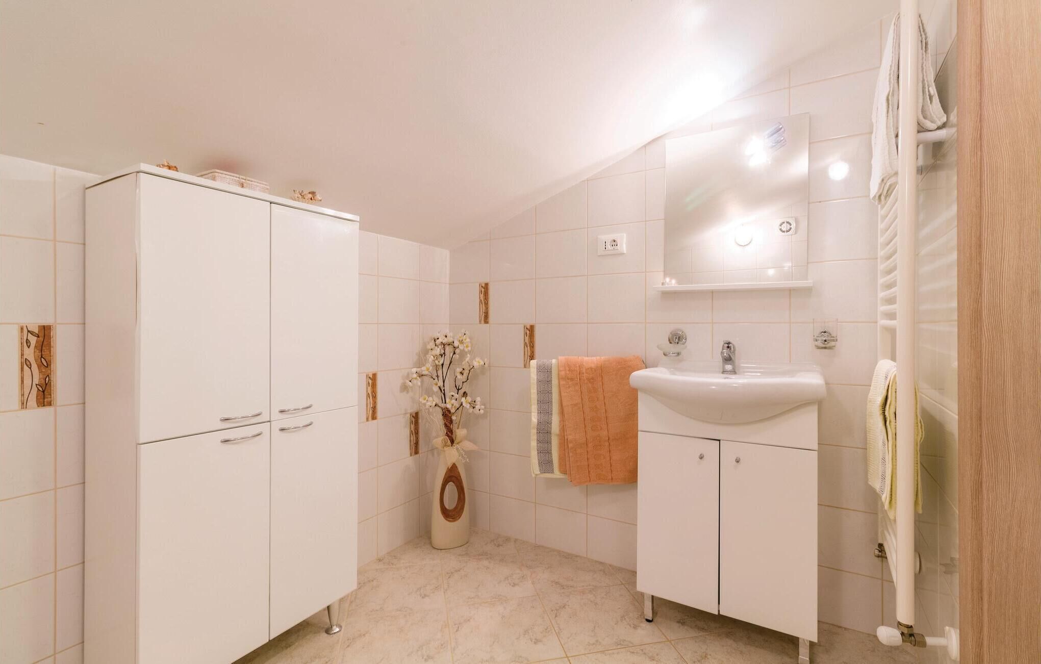 Un baño con un mueble blanco, un lavabo y un espejo.