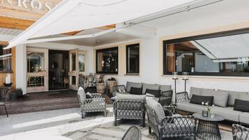 A hotel patio with wicker furniture, a sofa, and a table.