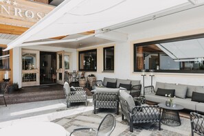 Un patio de hotel con mobiliario de mimbre, un sofá y una mesa.