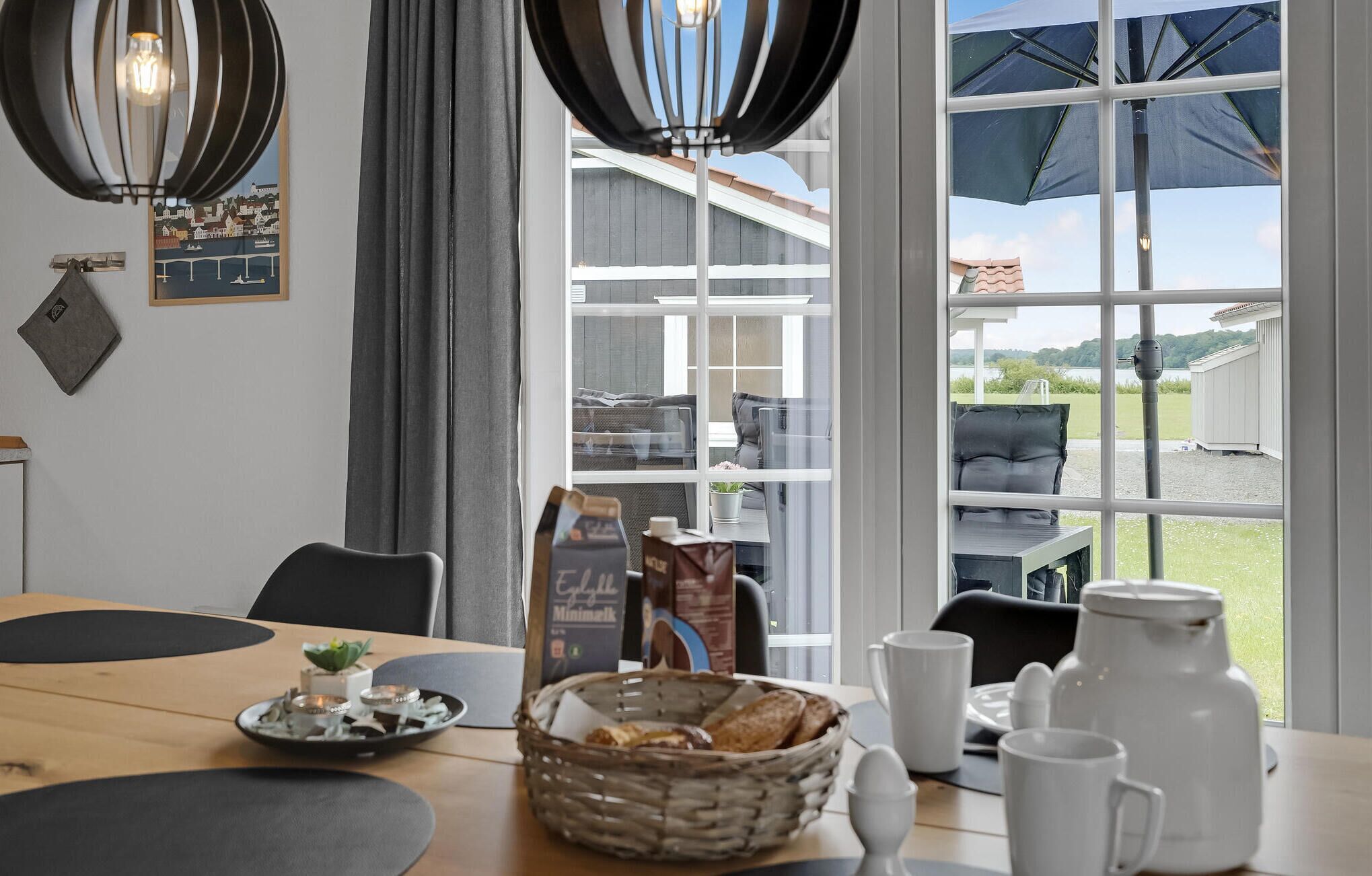Un coin repas avec une table mise pour le petit-déjeuner, comprenant du pain, des viennoiseries et des tasses à café.