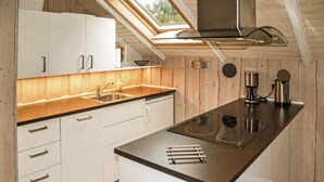 A modern kitchen with white cabinets, a black countertop, a stainless steel range hood, and a coffee maker. - 3 bedroom gorgeous home in Oksbøl (Oksbøl)