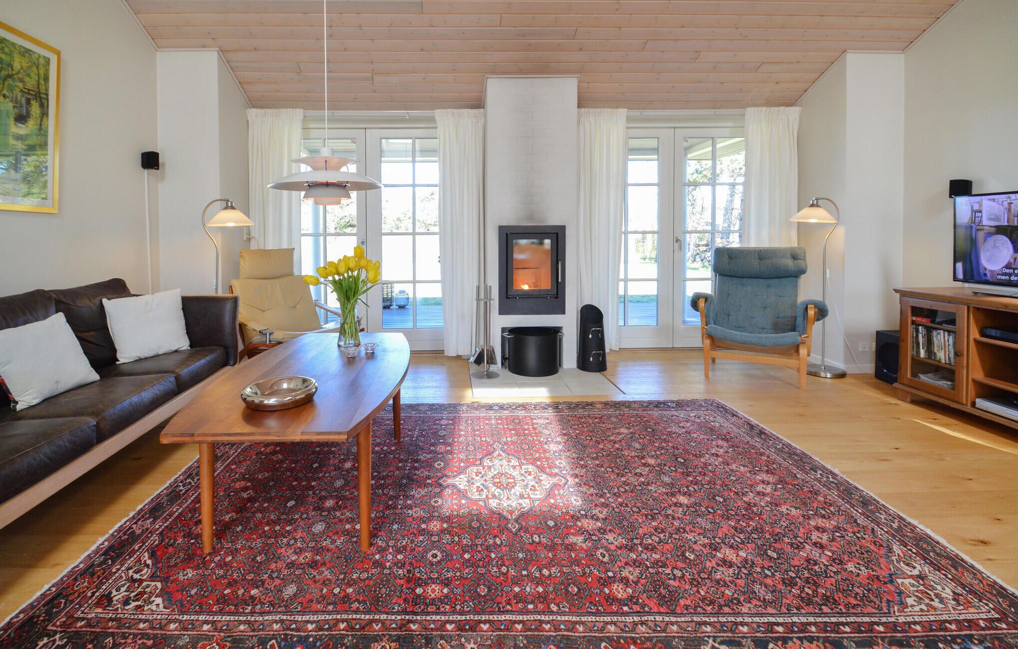 A living room with a sofa, a coffee table, a fireplace, a TV, and a bookshelf.