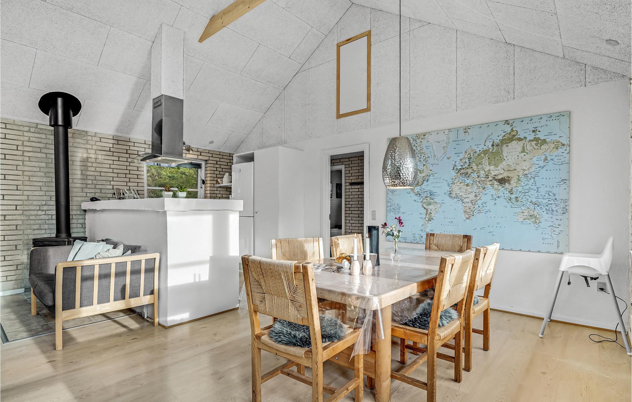 Une cuisine moderne avec une grande carte du monde, des chaises en bois et une table à manger.