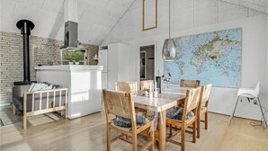 Una cocina moderna con un gran mapa mundial, sillas de madera y una mesa de comedor.