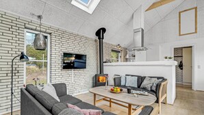 Una sala de estar moderna con chimenea, un sofá, una mesa de centro y un televisor.