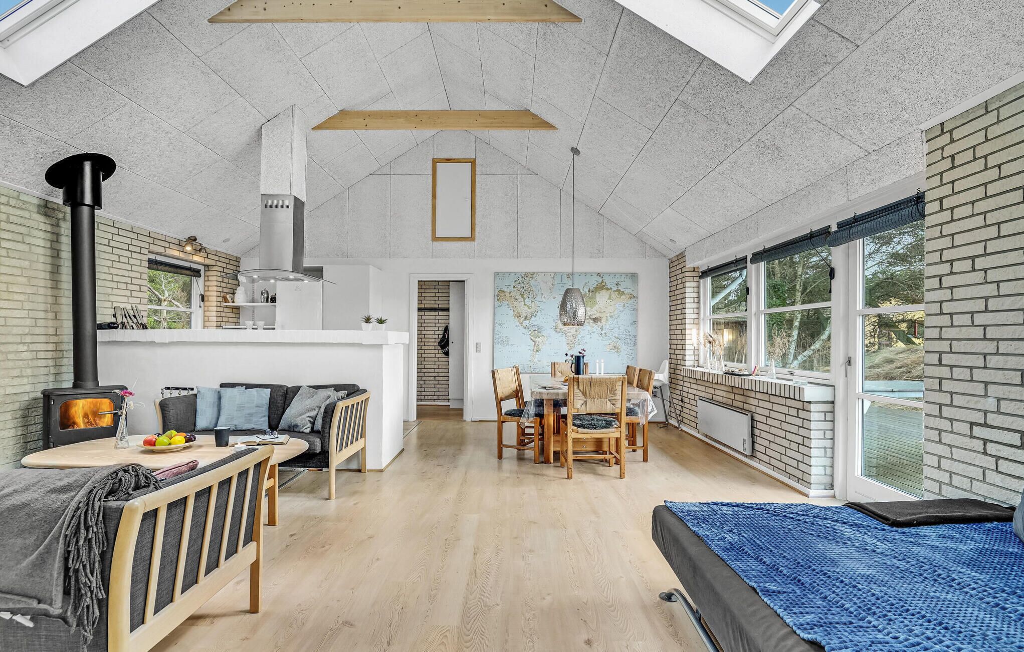 Un loft spacieux avec de hauts plafonds, des murs en briques apparentes, un grand espace de salle à manger et un coin salon confortable avec une cheminée.