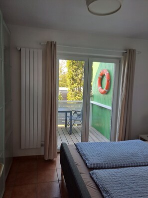 Ein Zimmer mit Bett, Ausblick nach draußen und grüner Wand.