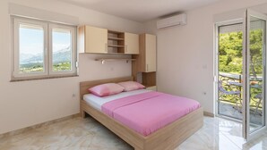 Un dormitorio con cama, ventana, balcón y armario empotrado.