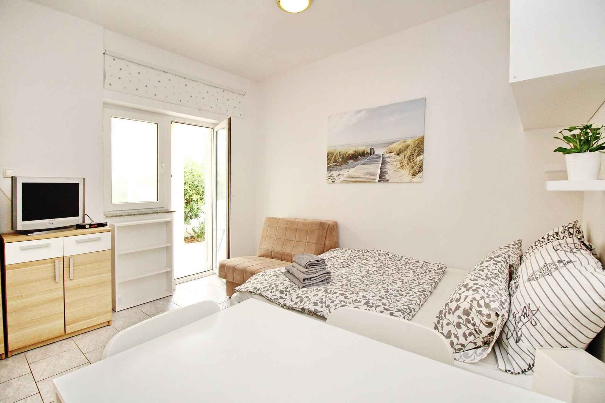 Un dormitorio moderno con una cama, televisión, sofá y un cuadro en la pared.