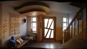 Una habitación con un banco de madera, un escritorio y un ventanal con vistas.