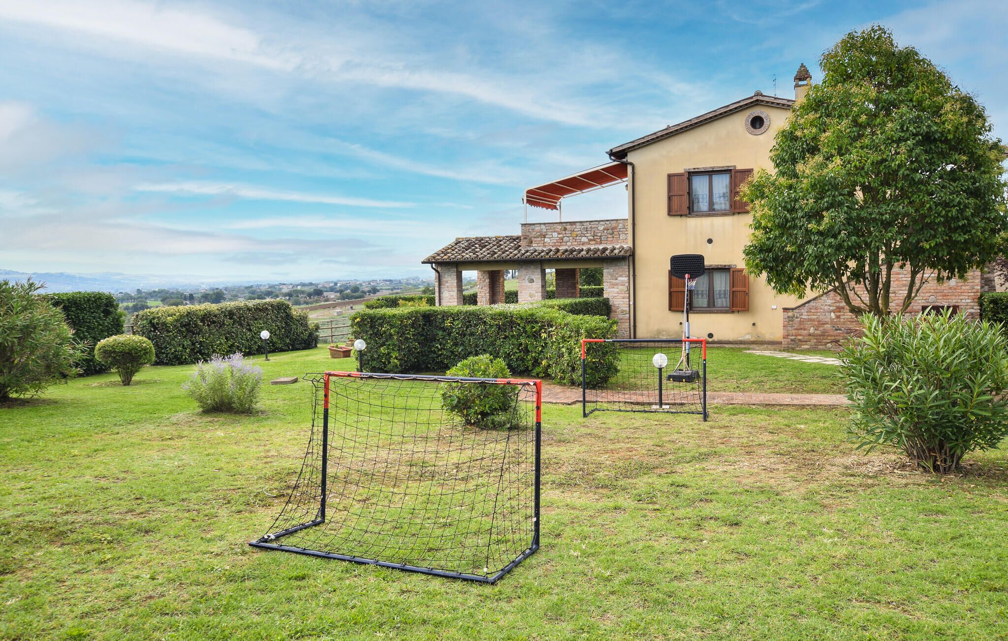 Una casa con jardín, una portería de fútbol y un aro de baloncesto.
