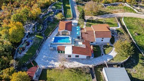 Ein großes Haus mit Swimmingpool, mehreren Zimmern und einem gepflegten Garten.