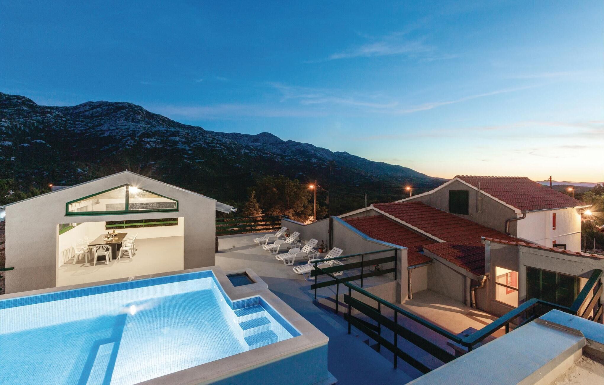 Un área de piscina moderna con una vista despejada de las montañas al fondo.