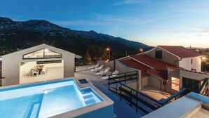 Ein moderner Poolbereich mit freiem Blick auf die Berge im Hintergrund.
