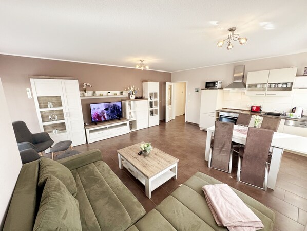 A modern apartment with a living room, dining area, and kitchen.
