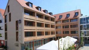 Ein mehrstöckiges Hotel mit Balkonen, einer flachen Dachkonstruktion und einem modernen architektonischen Stil.