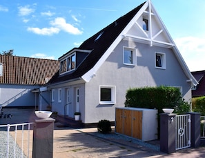 A modern house with a sloped roof, a fenced driveway, and a gated entrance. - Vacation apartment Timmi 4, 2-room apartment for 4 persons, ground floor - Ocean Way House (Scharbeutz)