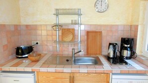 Una cocina con un lavamanos, cafetera, tostadora y lavavajillas.