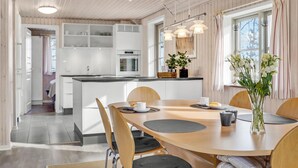 A modern kitchen with white cabinets, a central island, and pendant lighting.