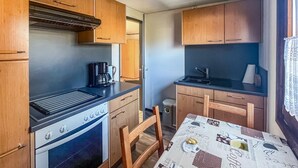 A compact kitchenette with a stove, coffee maker, and sink. - 2 bedroom nice home in Oberelbert (Oberelbert)