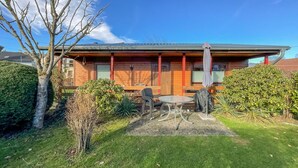 A wooden cabin with a patio, a dining table, and chairs. - 2 bedroom nice home in Oberelbert (Oberelbert)