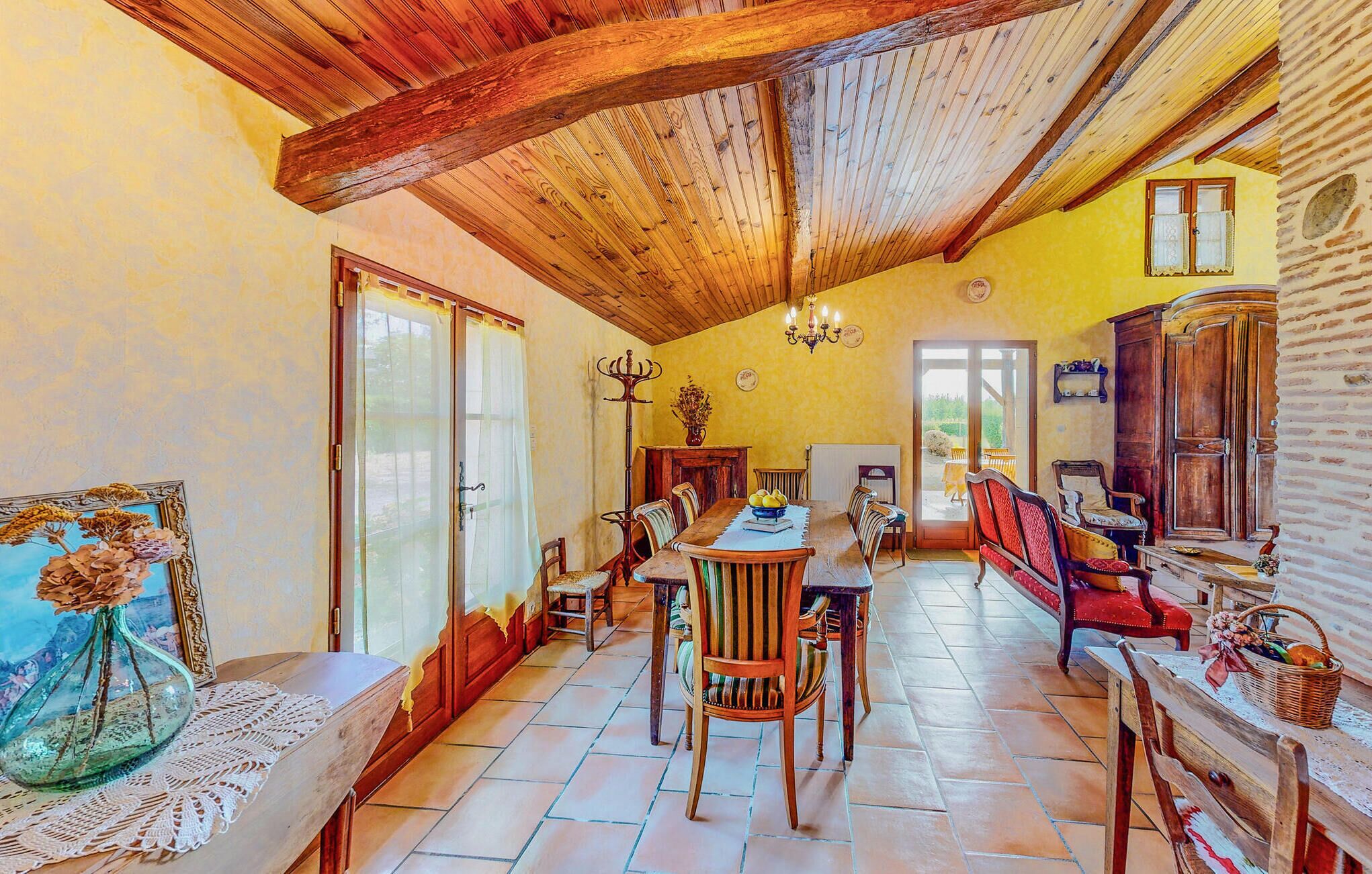 A spacious dining area with a high wooden ceiling, a large table, and multiple chairs.