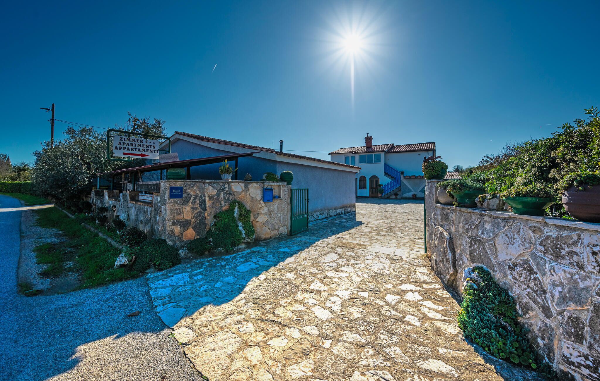 Un camino de piedra que lleva a un edificio con un letrero que dice 'Zimmer Apartments'.