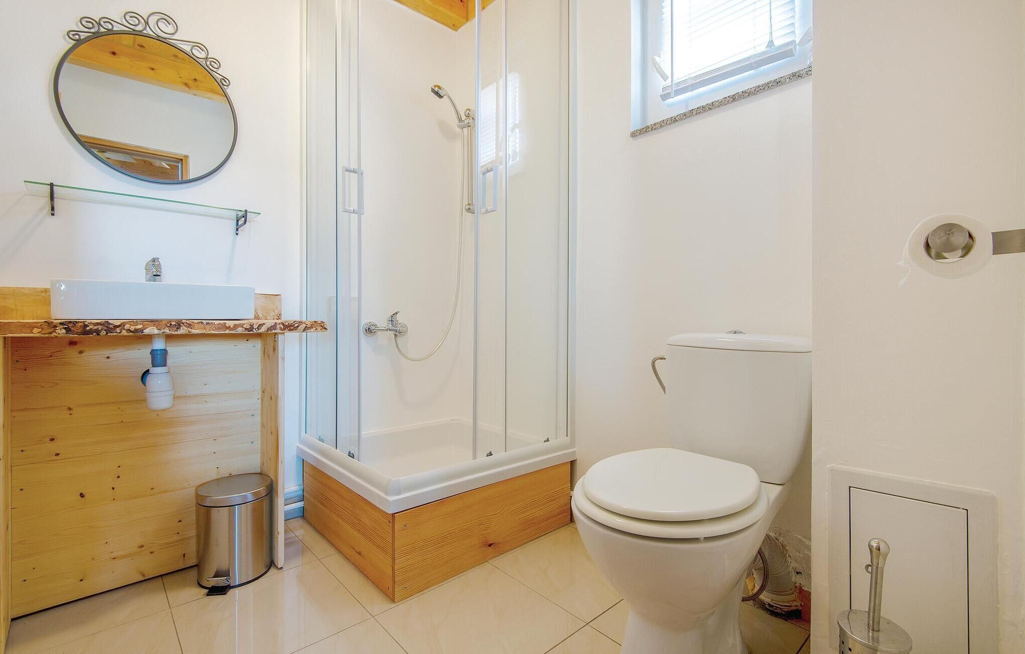 A bathroom with a shower, toilet, and sink.