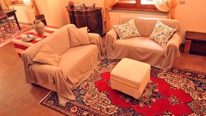 A cozy living room with two sofas, a coffee table, and a patterned rug. - Holiday apartment mit Pool (Vicchio)