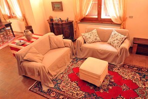 Un accogliente soggiorno con due divani, un tavolino e un tappeto decorato.