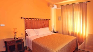 A hotel room with a bed, a nightstand, a lamp, and a window with curtains. - Holiday apartment mit Pool (Vicchio)