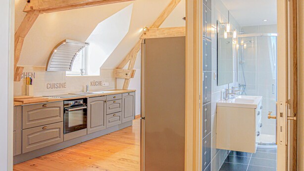 An attic-style kitchen with wooden beams, a built-in oven, and a large window. - 2 bedroom amazing apartment in Ponts (Ponts)
