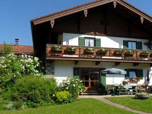 Un bâtiment à deux étages doté d’un balcon, d’un jardin et d’un espace patio.