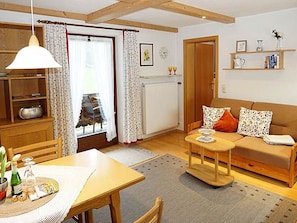 Ein gemütliches Wohnzimmer mit Holztisch, einer Couch und einem Essbereich.