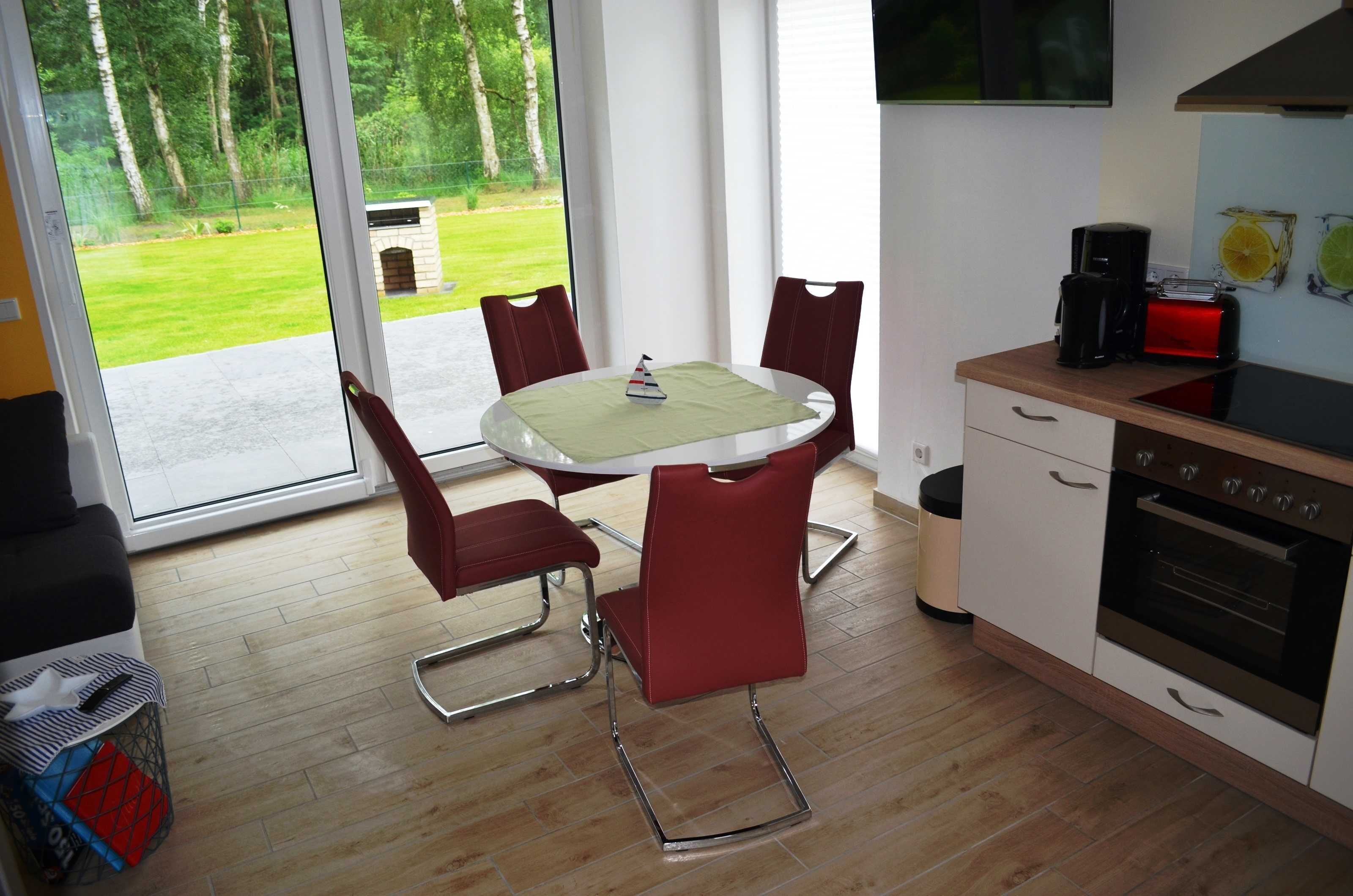 Een moderne keuken met een eettafel, stoelen, een koffiezetapparaat en een oven.