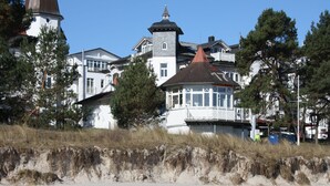 Ein großes, mehrstöckiges Gebäude mit einem markanten Turm und einem rot gedeckten Bau.