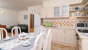 Una cocina compacta con comedor, que incluye un microondas, una estufa a gas y un lavamanos.