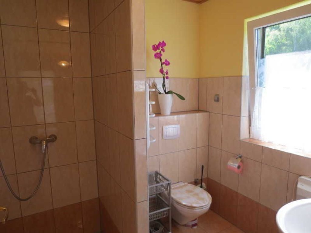 Un baño con inodoro, ducha y ventana.