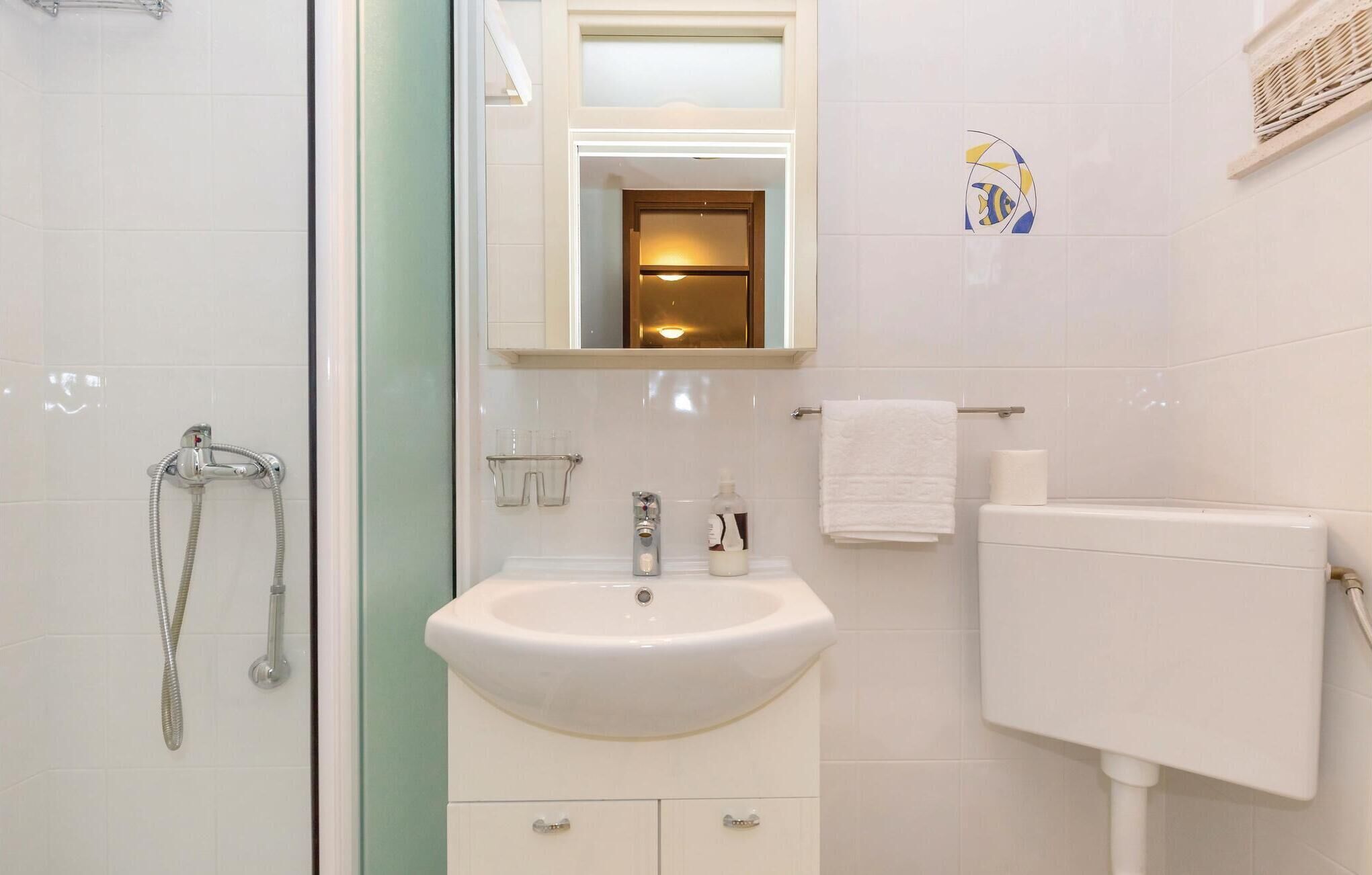 Ein Badezimmer mit Dusche, Waschbecken und Toilette.