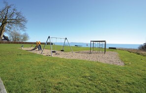 Relax and play in this serene outdoor space with a swing set, slide, and climbing structure.