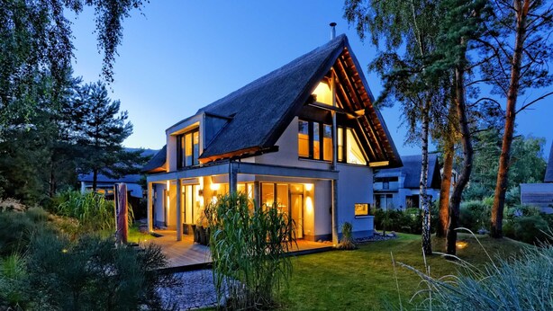 Una casa moderna con tetto spiovente, ampie finestre e un ingresso luminoso.