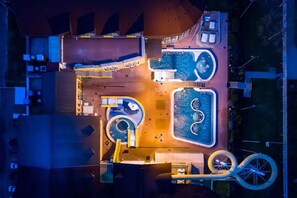 An aerial view of a hotel with multiple swimming pools, a central courtyard, and a bicycle path. - Holiday apartment only 150 m from the thermal bath (Zalakaros)
