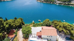 A coastal property with a swimming pool, a red-tiled roof, and a view of the sea. - Cozy apartment in Zaton Mali (Zaton Mali)