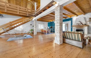 A spacious loft with exposed wooden beams, a stone fireplace, and a hammock. - Stunning home in Lozovac (Lozovac)